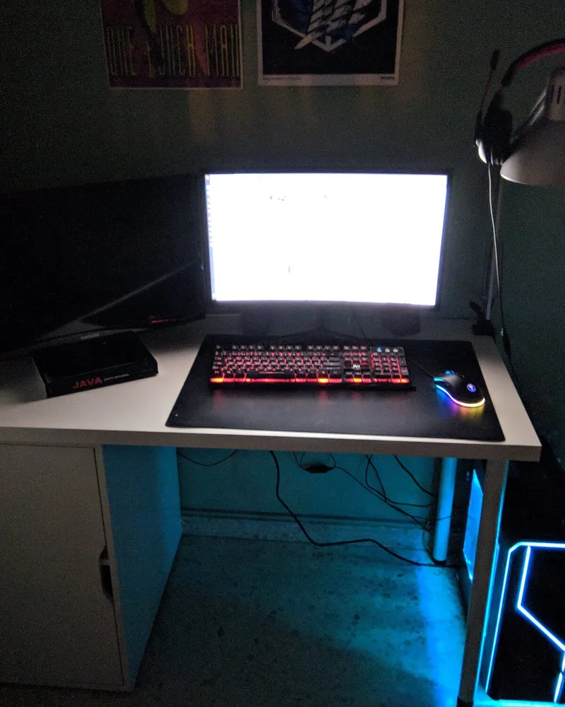 My desk in 2018: a monitor switched on, a red backlit keyboard and a Java book on the table.